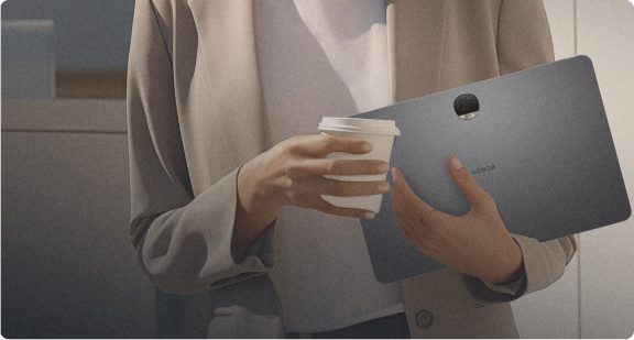 Person holding an HONOR tablet and a coffee