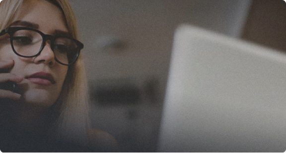 Woman on a call, looking at a laptop